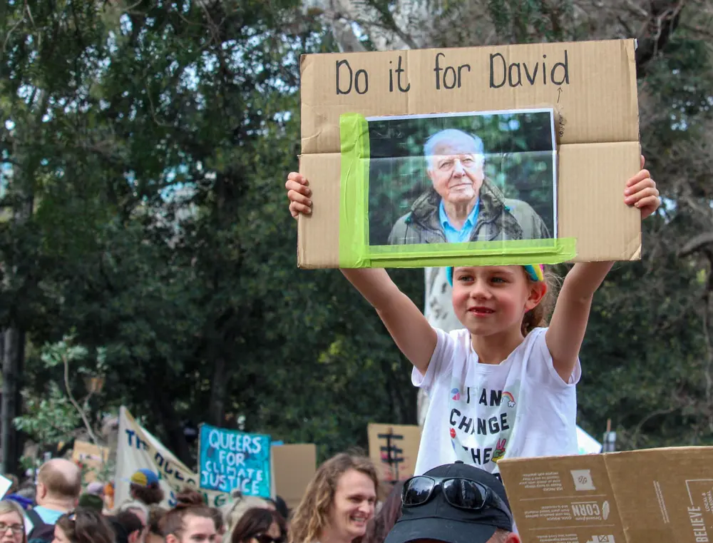 Picture of child campaigning for the environment with picture of Sir David Attenborough