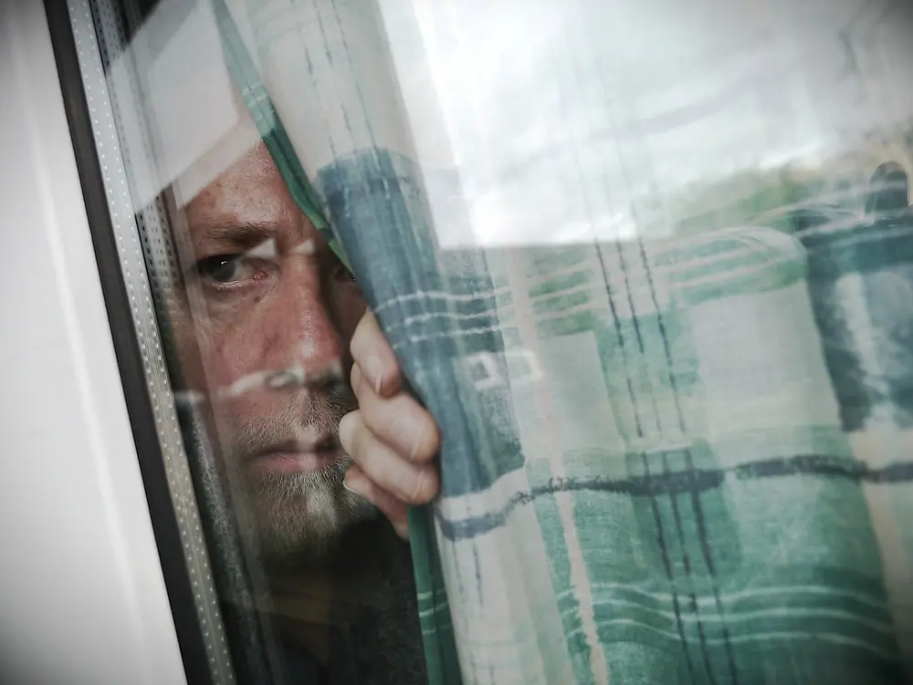 Image of neighbours looking out window anxious