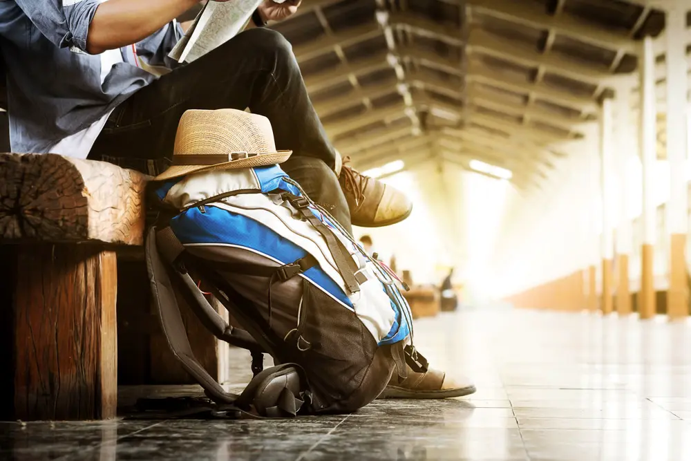 Image of person waiting for train, using one bag for minimalist travel