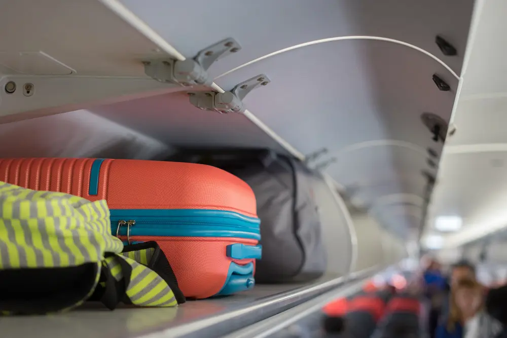 Image of hand luggage on a plane. The right luggage as the key to travel light success