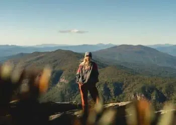 woman standing on cliff overview of mountain in landscape photography